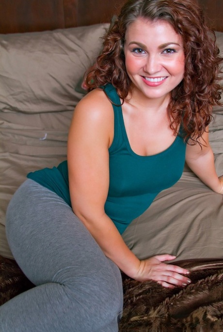 Pretty smiling Stephy Parker lifts her tight shirt to show her nice big tits